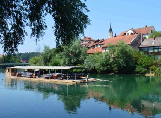 A tranquil sailing on board a traditional raft sailing on the Krka River near Novo Mesto